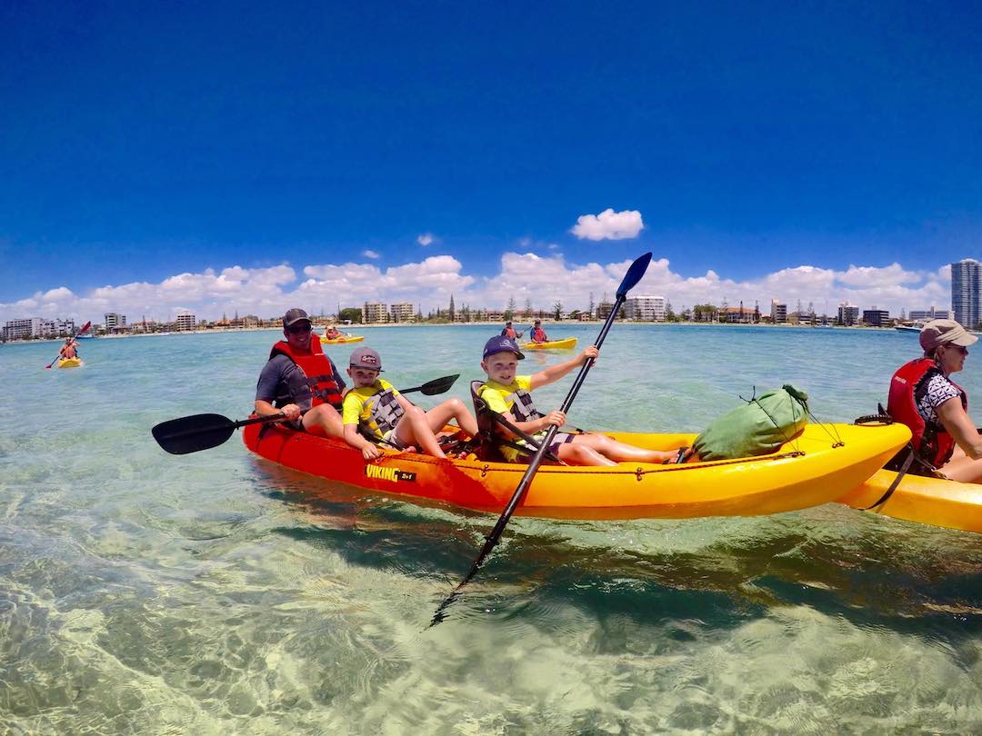 Three people paddling together in a three person kayak